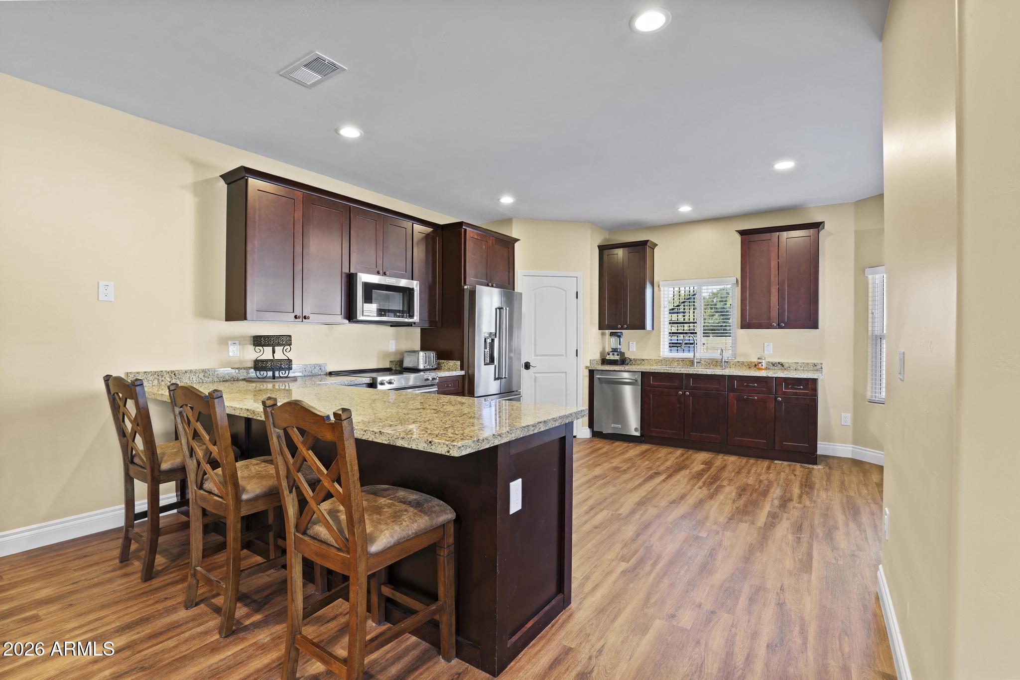 7705 Caballero Road Payson, AZ 85541 - Photo 29 of 43 a kitchen with a sink a center island cabinets and a window