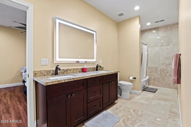 a bathroom with a granite countertop sink toilet and shower