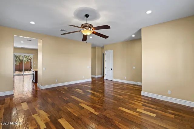 a view of an empty room with window and wooden floor