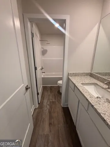 a bathroom with a granite countertop sink toilet and shower