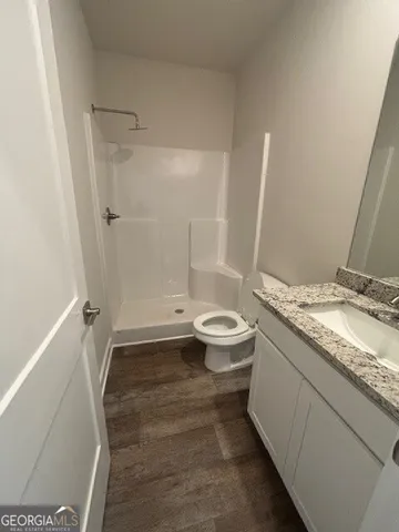 a bathroom with a granite countertop sink toilet and shower