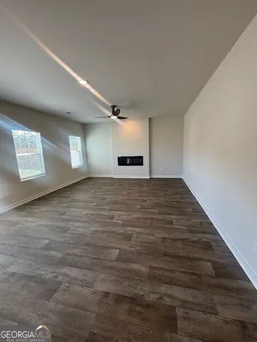 a view of an empty room with a window and fireplace