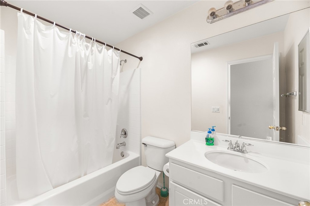 1339 Addison Way Perris, CA 92571 - Photo 23 of 67 a bathroom with a sink a toilet and shower curtain