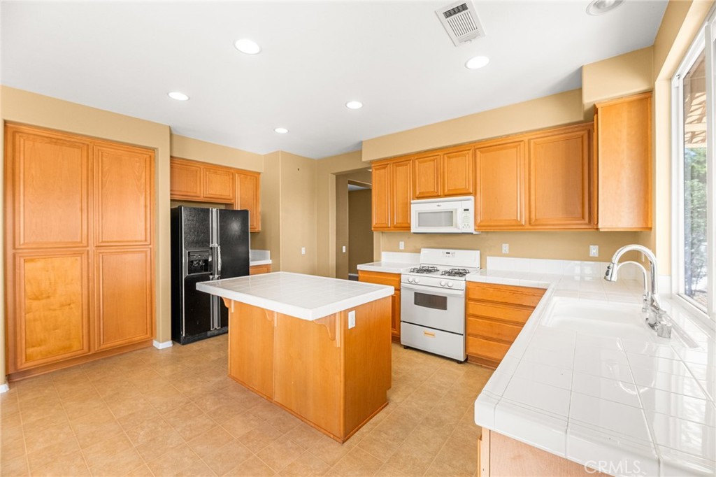 1339 Addison Way Perris, CA 92571 - Photo 5 of 67 a kitchen with stainless steel appliances granite countertop a sink stove and refrigerator