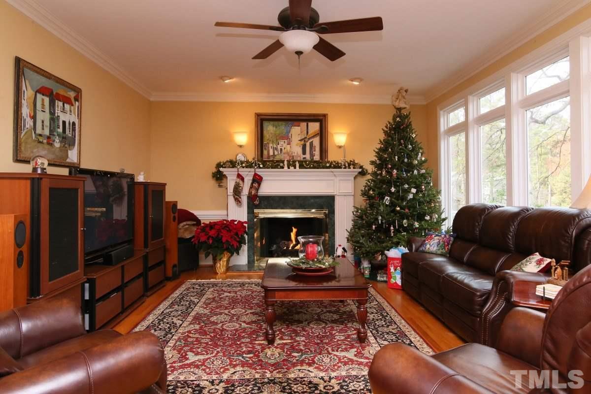 2908 Ballybunion Way Raleigh, NC 27613 - Photo 5 of 25 a living room with furniture a fireplace and a flat screen tv