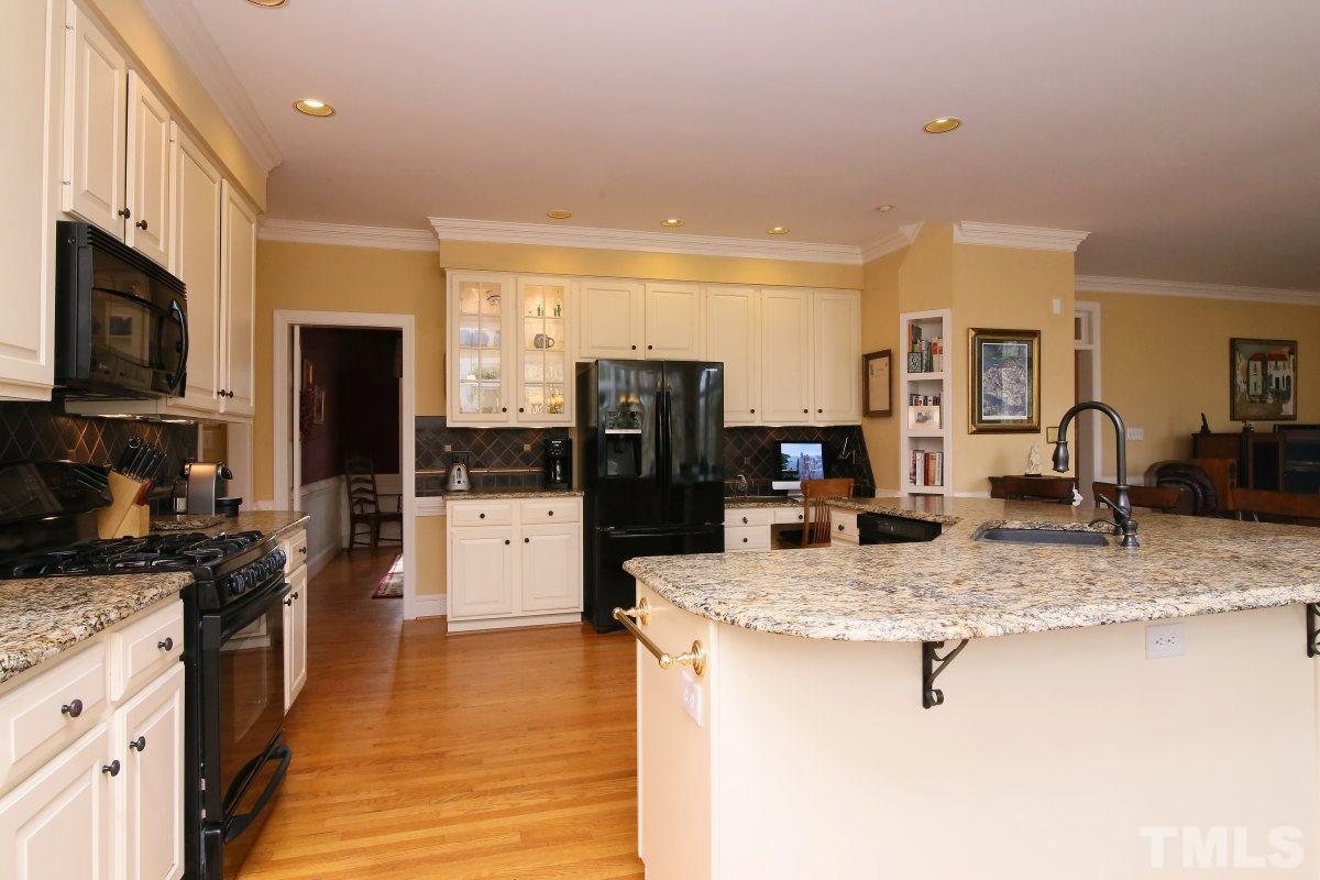 2908 Ballybunion Way Raleigh, NC 27613 - Photo 7 of 25 a kitchen with stainless steel appliances granite countertop a sink stove and refrigerator