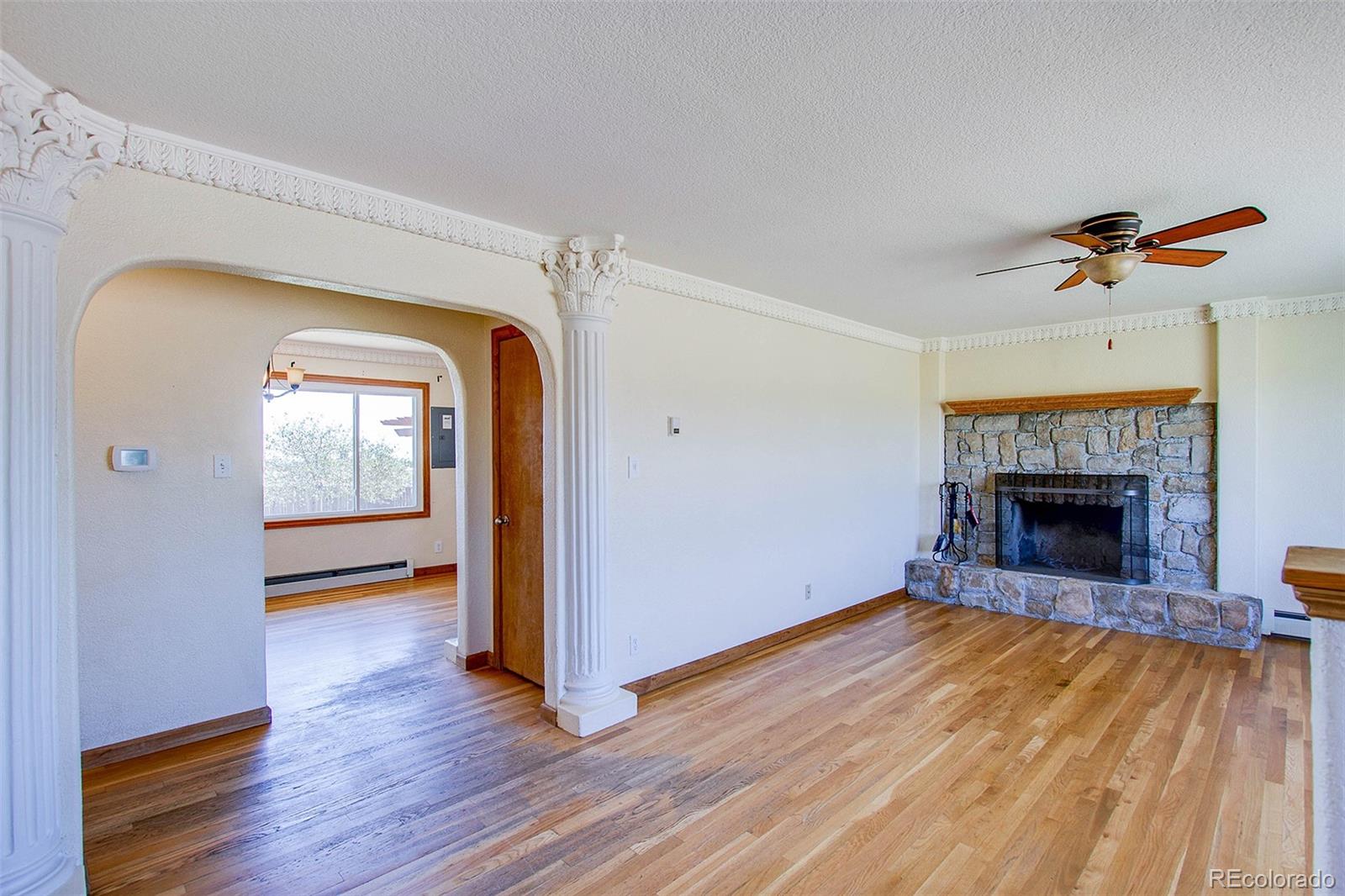 5475 Meridian Road Peyton, CO 80831 - Photo 4 of 35 a view of a livingroom with wooden floor and a fireplace