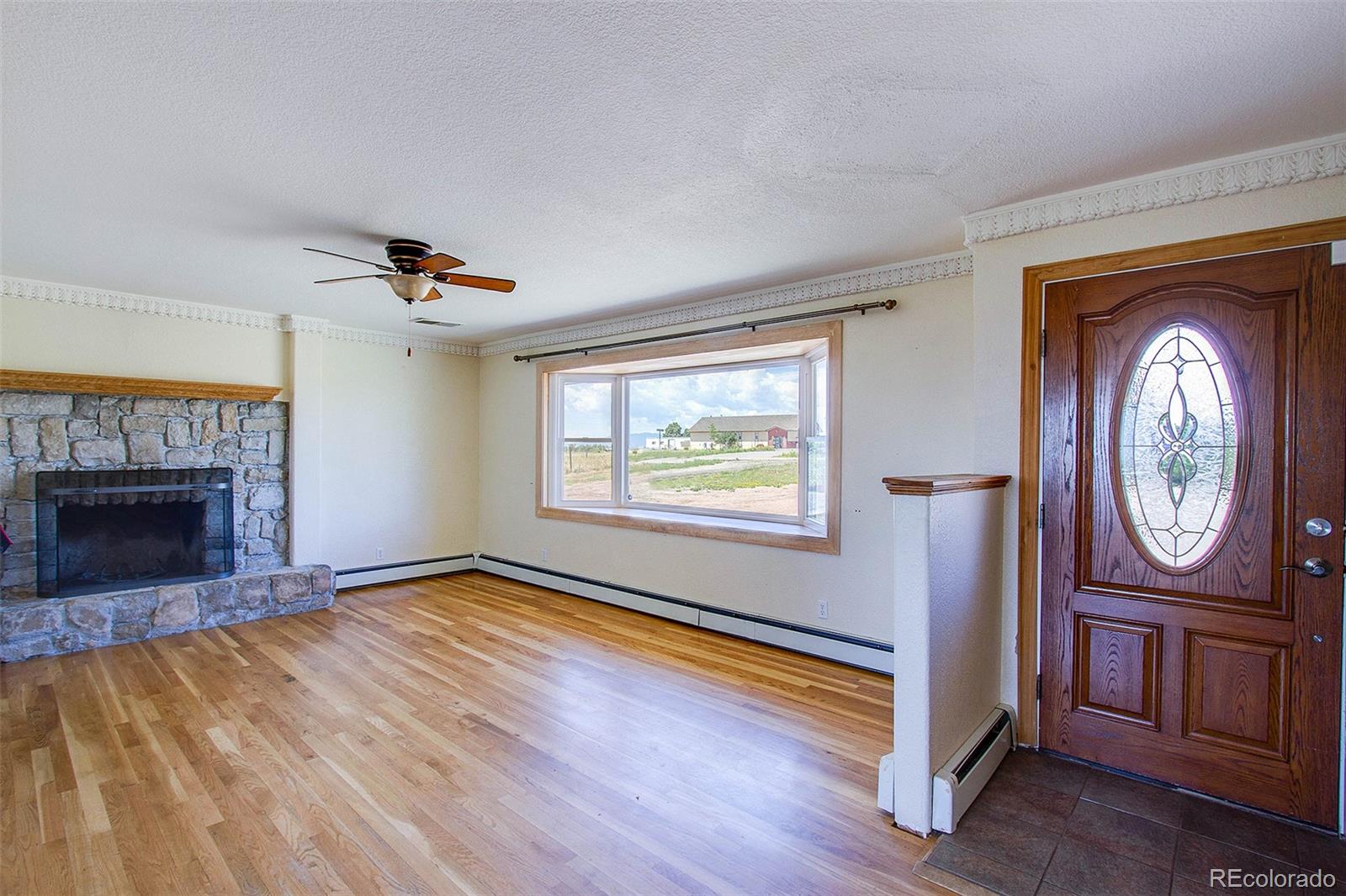 5475 Meridian Road Peyton, CO 80831 - Photo 5 of 35 a view of an empty room with a fireplace and a window