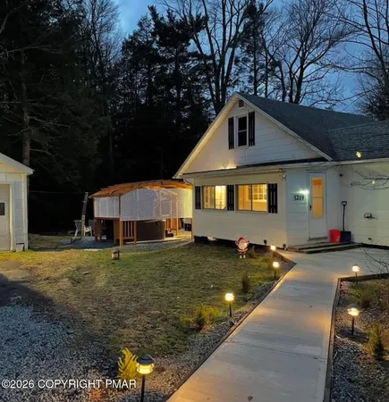 a view of house with backyard entertaining space and garden