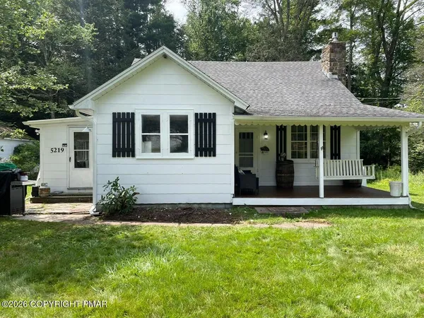 a backyard of a house with sofas fire pit and outdoor seating