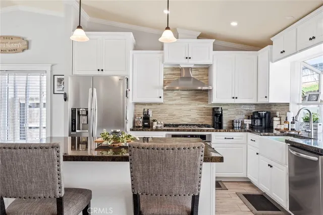a kitchen with stainless steel appliances kitchen island granite countertop a stove a sink and a refrigerator