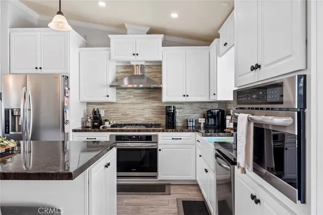 a kitchen with cabinets stainless steel appliances and wooden floor
