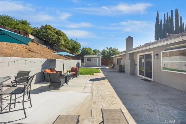 a view of a patio with table and chairs and floor to ceiling window