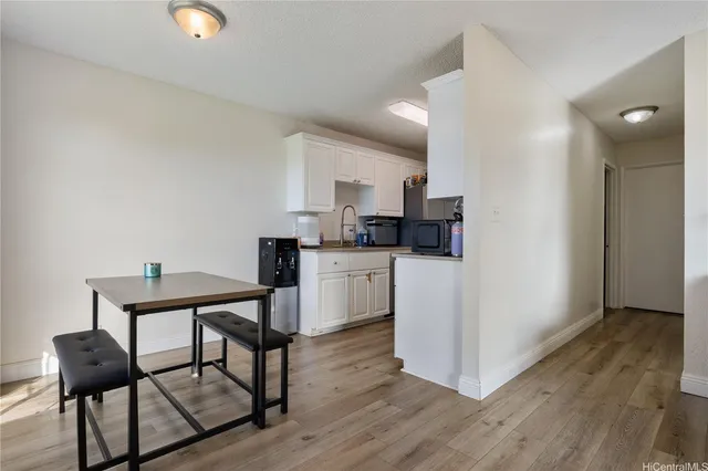 a kitchen with a table chairs refrigerator and microwave