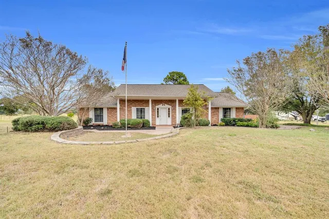 a front view of a house with a yard and trees
