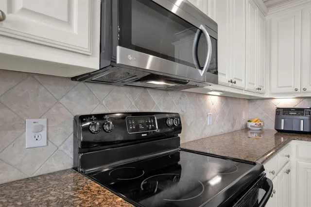 a kitchen with a stove and white cabinets