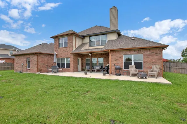 a view of a house with a big yard potted plants and large tree