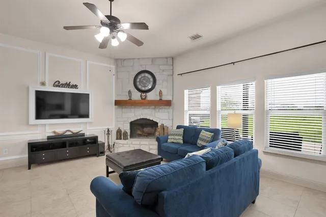 a living room with furniture a flat screen tv and a fireplace