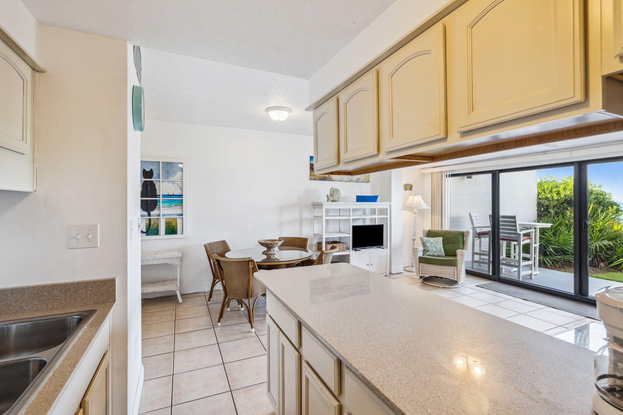 3722 East County Highway 30A, Unit 3 Santa Rosa Beach, FL 32459 - Photo 10 of 22 a kitchen with stainless steel appliances kitchen island granite countertop a table chairs in it and a wooden floor