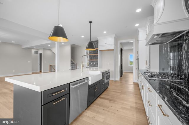 a large kitchen with stainless steel appliances a stove a sink a refrigerator and a stove