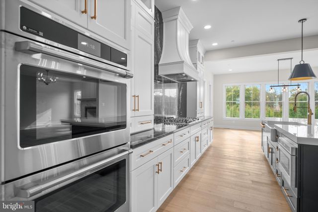 a large kitchen with stainless steel appliances and large windows