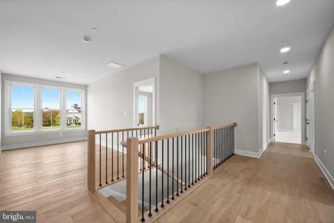 a view of a hallway with wooden floor and windows