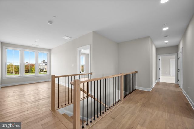a view of a hallway with wooden floor and windows