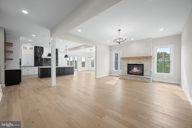 a view of a big room with wooden floor and a kitchen