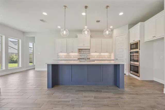 a large kitchen with kitchen island a sink stainless steel appliances and cabinets