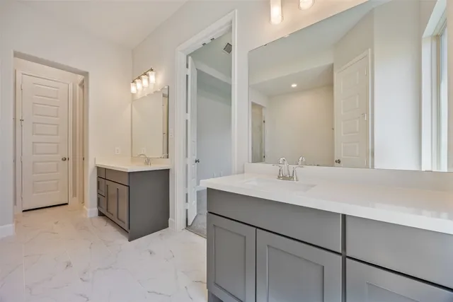 a bathroom with a double vanity sink a mirror and a bathtub