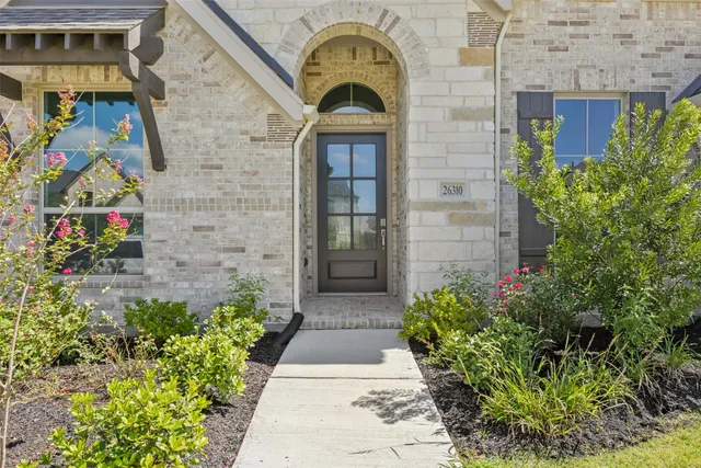 a stone house with potted plants in front of it
