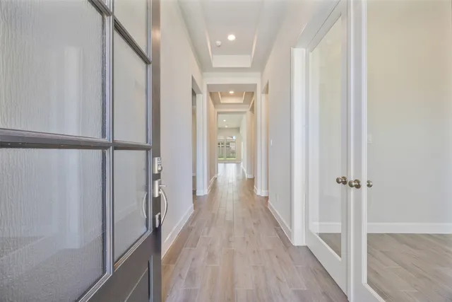 a view of a hallway with wooden floor and staircase