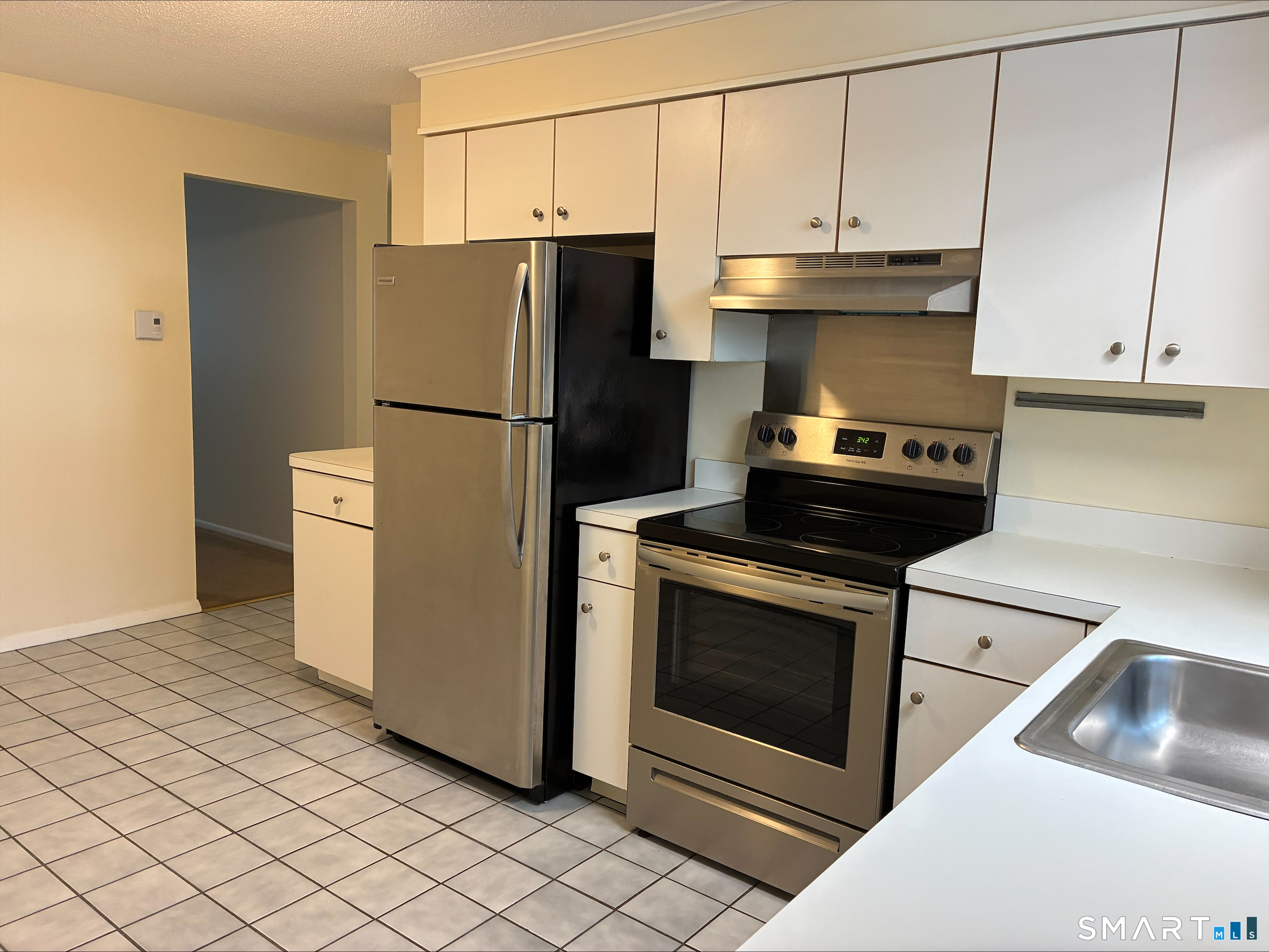26 College Street, Unit 2 Clinton, CT 06413 - Photo 9 of 27 a kitchen with a refrigerator stove and cabinets