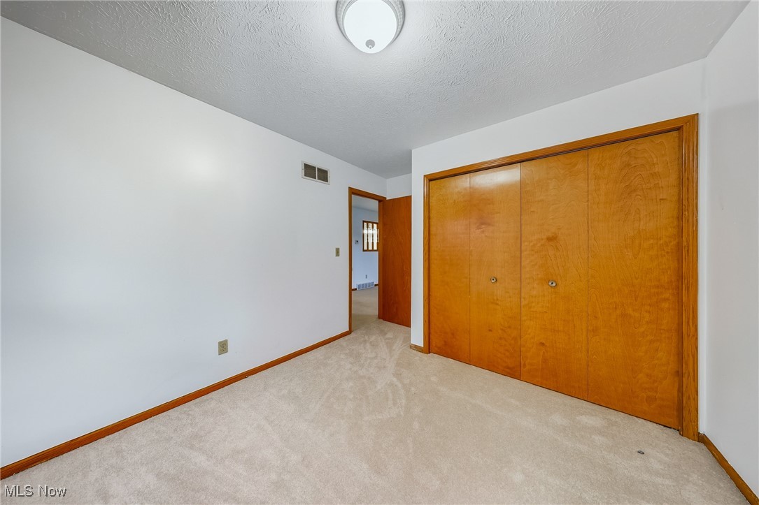 425 Overlook Drive Rittman, OH 44270 - Photo 29 of 44 Unfurnished bedroom with a textured ceiling, a closet, and light carpet
