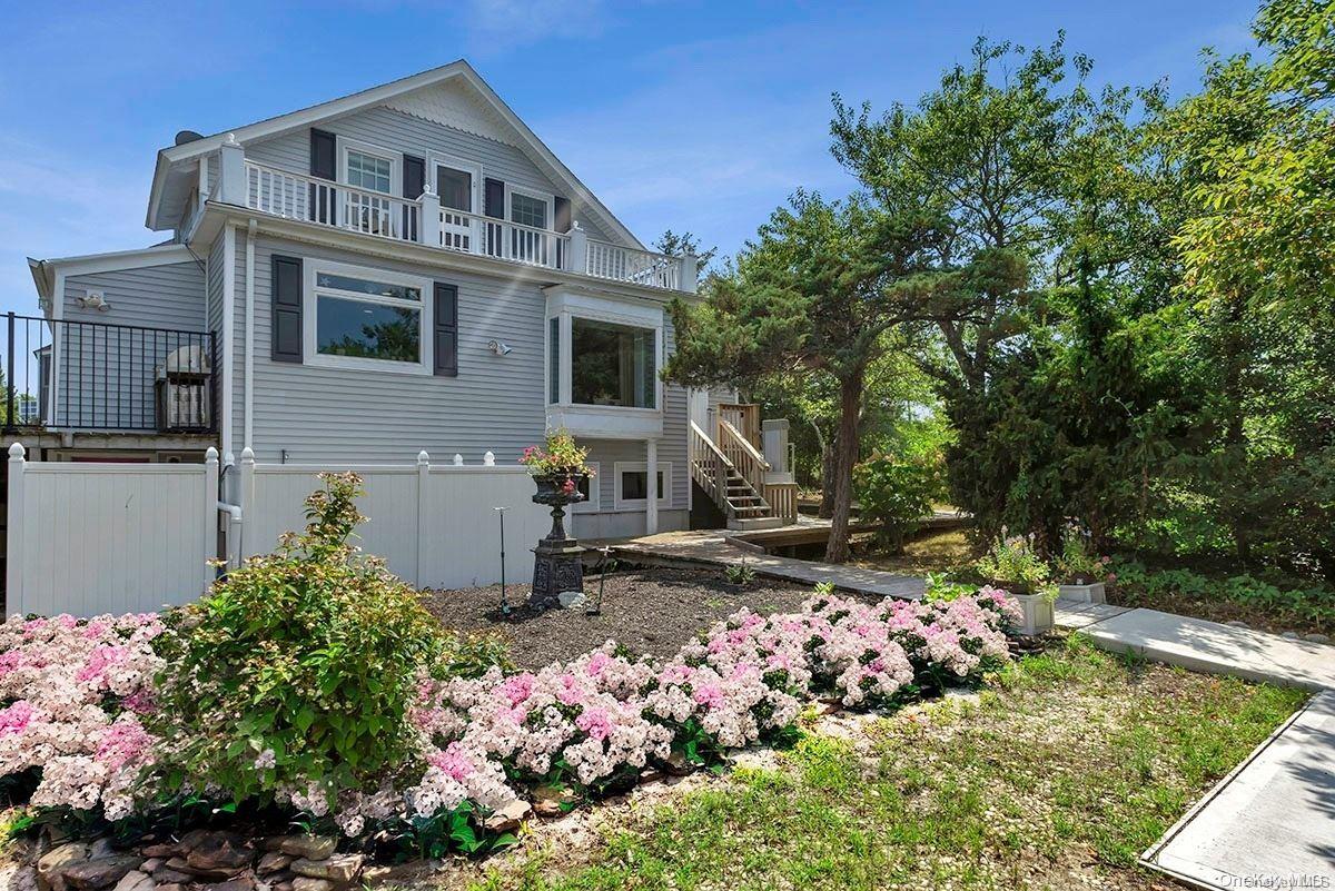 32 Sandy Drive Oak Beach, NY 11702 - Photo 1 of 1 a front view of a house with a yard and a garden