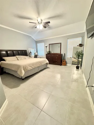 a spacious bedroom with a bed a couch and dresser