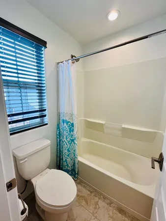 a white toilet sitting next to a bath tub