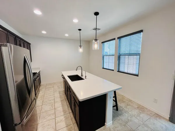 a kitchen with stainless steel appliances granite countertop a refrigerator a sink and a stove