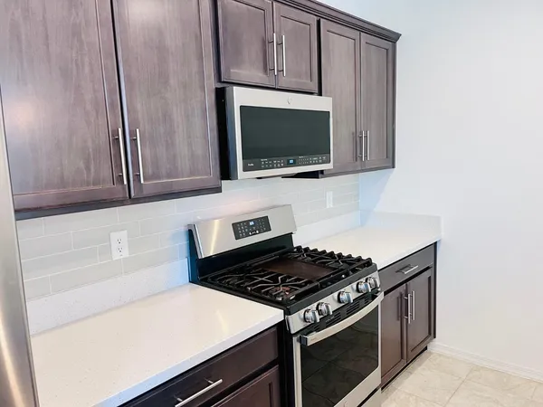 a kitchen with wooden cabinets and a stove top oven