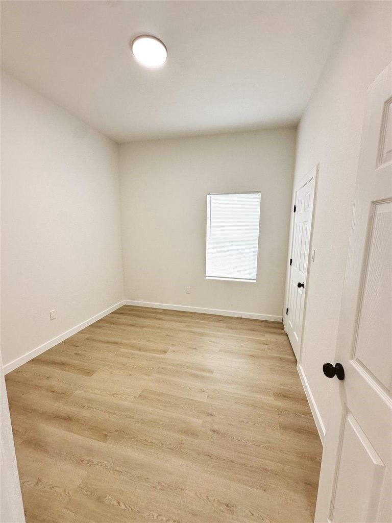 9705 Garcroft Street, Unit A Houston, TX 77029 - Photo 12 of 21 a view of an empty room with wooden floor and a window