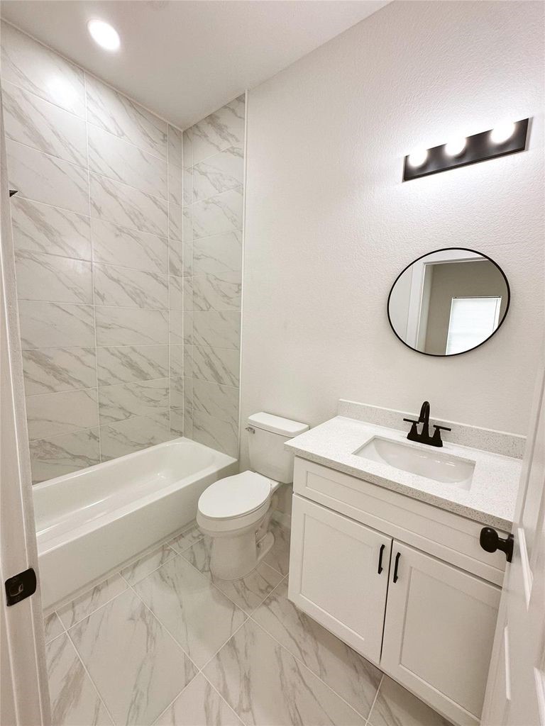 9705 Garcroft Street, Unit A Houston, TX 77029 - Photo 16 of 21 a bathroom with a sink a toilet and a bathtub