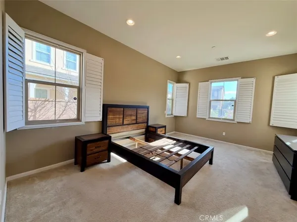 a room with lots of white furniture and wooden floor