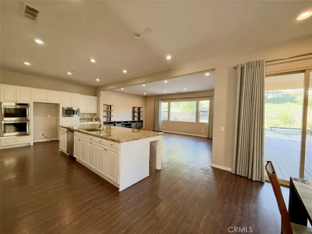 a view of a kitchen with furniture and wooden floor