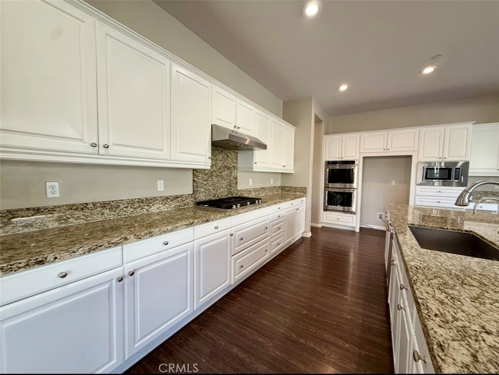 667 Desert Willow Road Azusa, CA 91702 - Photo 32 of 75 a large kitchen with granite countertop a sink a counter top space and stainless steel appliances