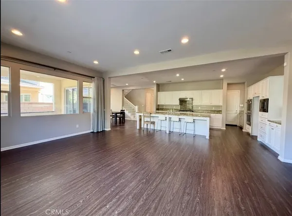 a view of an empty room with stairs and a window
