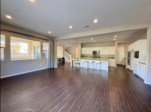 a view of an empty room with stairs and a window