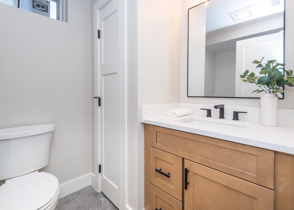 89 Hardy Pond Road Waltham, MA 02451 - Photo 31 of 39 a bathroom with a granite countertop sink vanity mirror and toilet