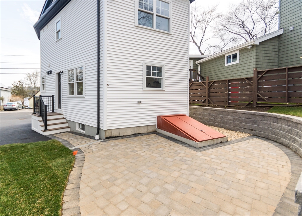 89 Hardy Pond Road Waltham, MA 02451 - Photo 36 of 39 a backyard of a white house with a small yard and large tree