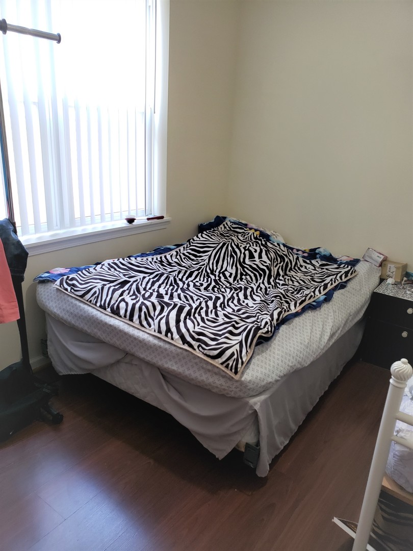 3554 South Dearborn Street Chicago, IL 60609 - Photo 7 of 22 a bed sitting in a bedroom next to a window