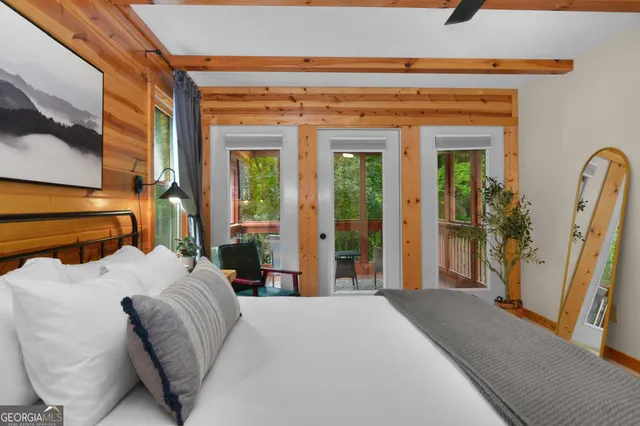 a bedroom with a bed and large windows